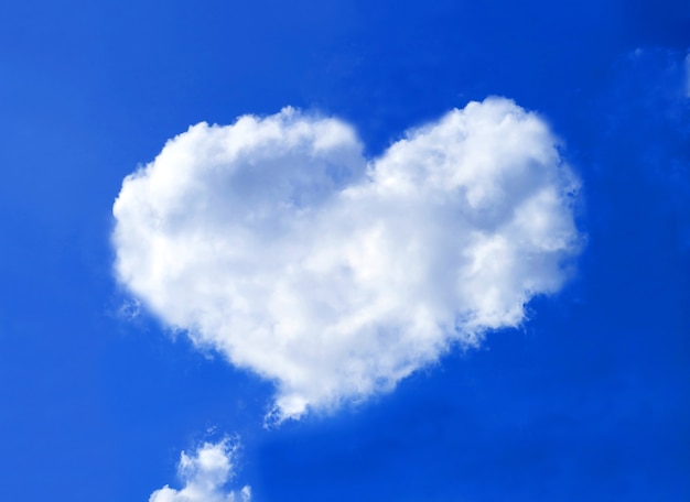Foto cúmulos esponjosos en forma de corazón flotando en el cielo azul vivo