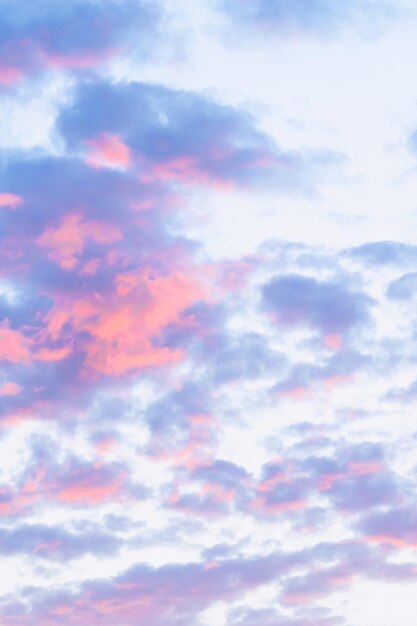 Cumulus cirrus nubes iluminadas por los rayos del sol poniente, foto vertical