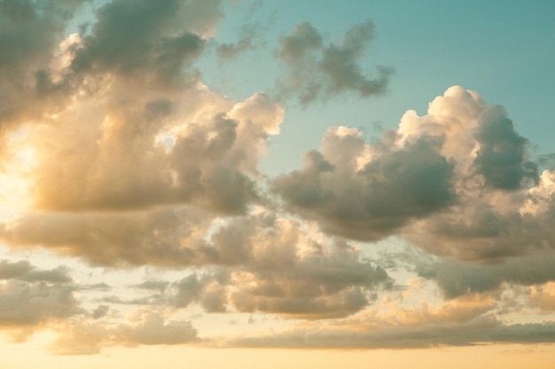 Cumulus-Wolken am Himmel bei Sonnenuntergang im Sommer, beleuchtet vom orangefarbenen Licht der Sonne. Himmlisches magisches Licht.