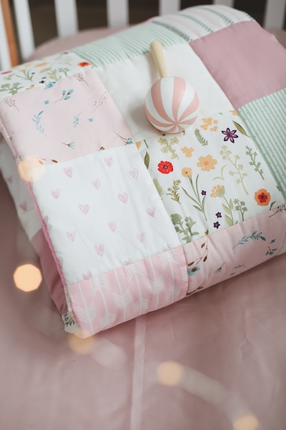 cuna con manta de patchwork rosa y textil para guardería infantil