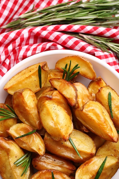 Las cuñas de patata al horno en la mesa de primer plano