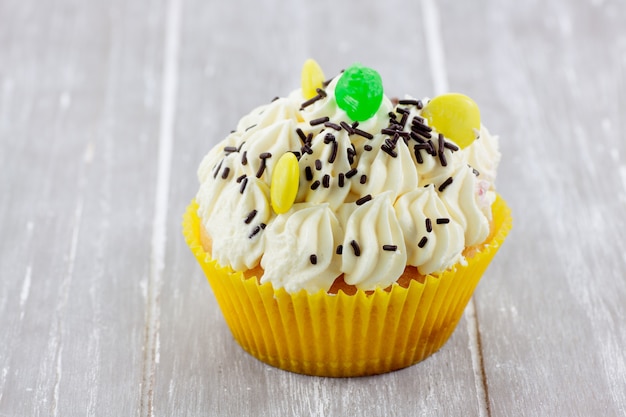 Cup cake de limón adornado con colores dulces y virutas de chocolate