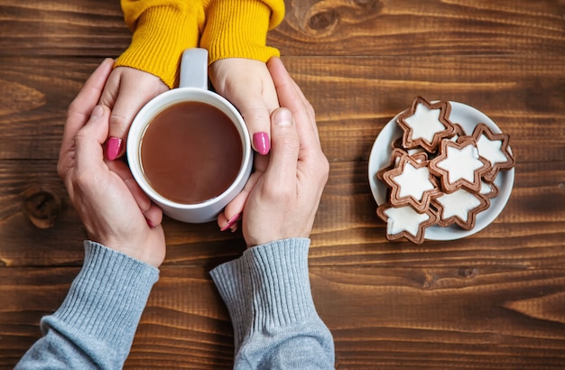 Cup-Drink zum Frühstück in den Händen der Liebenden. Selektiver Fokus