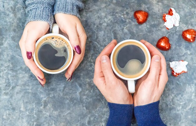 Cup-Drink zum Frühstück in den Händen der Liebenden. Selektiver Fokus
