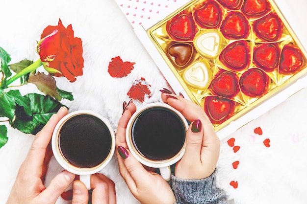 Cup-Drink zum Frühstück in den Händen der Liebenden. Selektiver Fokus