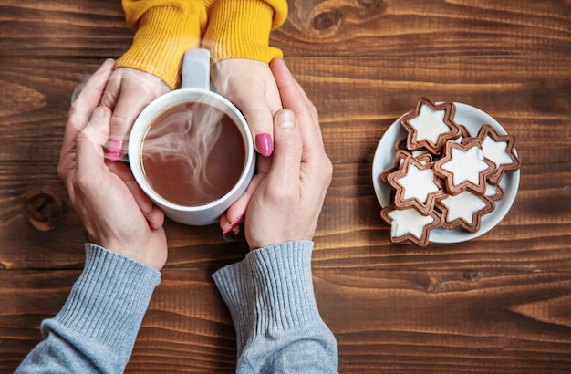 Cup-Drink zum Frühstück in den Händen der Liebenden. Selektiver Fokus