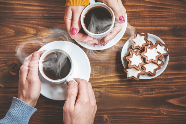 Cup-Drink zum Frühstück in den Händen der Liebenden. Selektiver Fokus