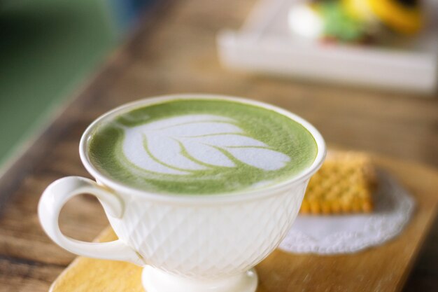 Cup Matcha Latte grüner Tee auf dunklem hölzernem Hintergrund.