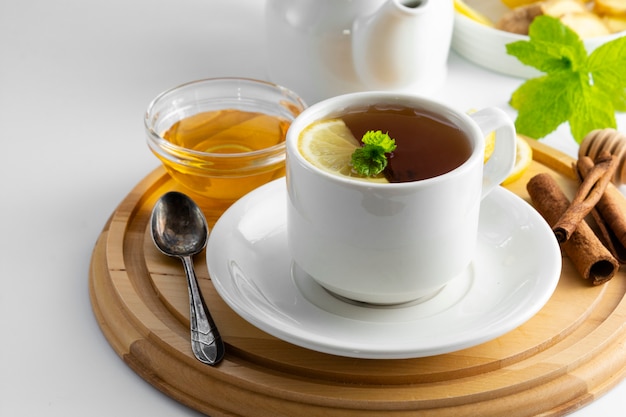 Cup Tee mit Zitrone und Honig auf einem weißen Hintergrund