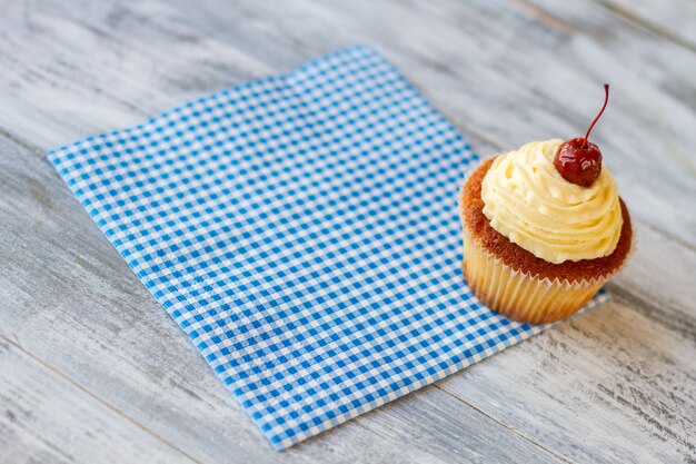 Cupcake auf karierter Serviettenkirsche auf kleinem Dessertgebäck im Diner einfach lecker und nahrhaft