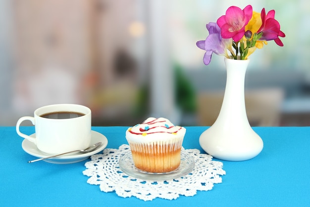 Cupcake auf Untertasse mit Glasdeckel auf Blau