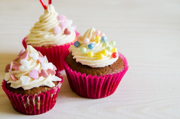 Cupcake de celebración para el día de San Valentín y feliz cumpleaños en mesa de madera blanca con corazones. Da amor en unas vacaciones