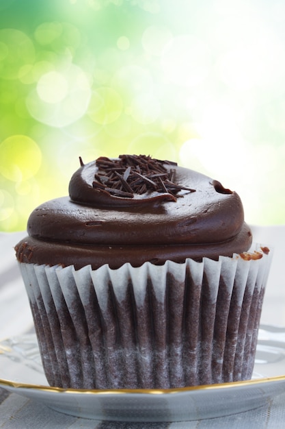 Un cupcake de chocolate fresco de cerca en el espacio verde bokeh