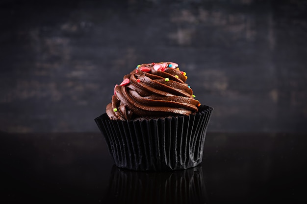 Cupcake colorido sabroso aislado en negro