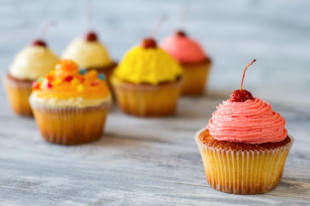 Cupcake com cobertura de cereja rosa em cima da sobremesa, cura de confeitos recém-assados de mau humor