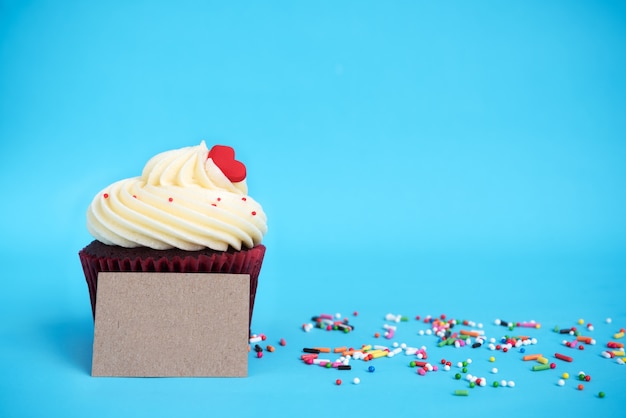 Cupcake com coração vermelho, colorido polvilha e nota marrom