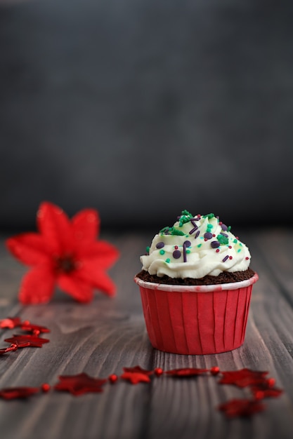 Cupcake com decoração de ano novo e uma flor de Natal ao fundo Concept food holidays