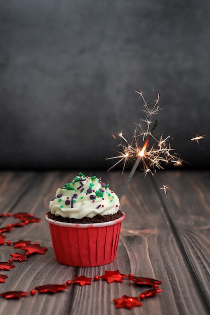 Cupcake com decoração de ano novo em um fundo escuro. Conceito de comida, férias, feliz ano novo.