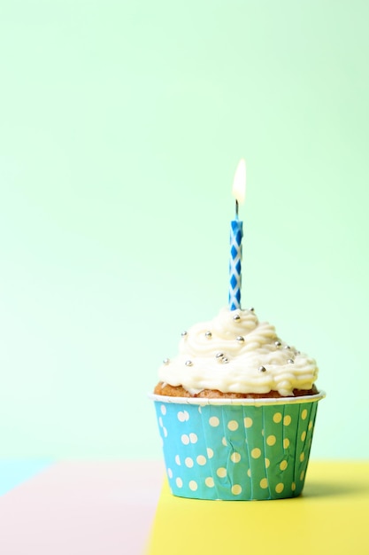 Cupcake de cumpleaños delicioso en mesa sobre fondo claro