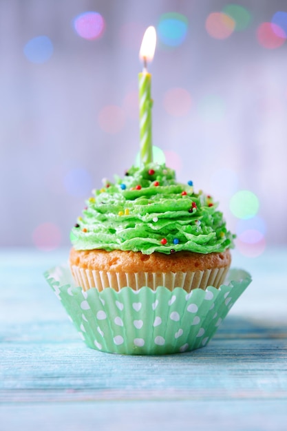 Cupcake de cumpleaños delicioso en mesa sobre fondo claro