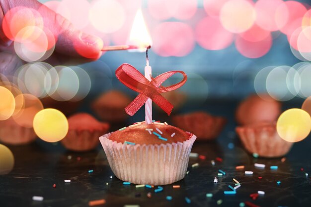 Cupcake de aniversário com bokeh de vela