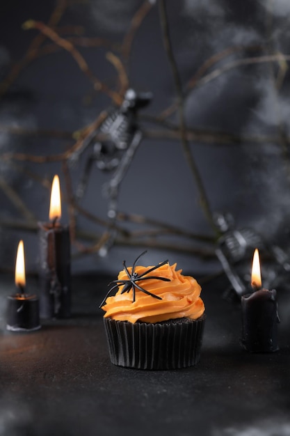 Cupcake de Halloween com decoração de buttercream de abóbora e aranha.