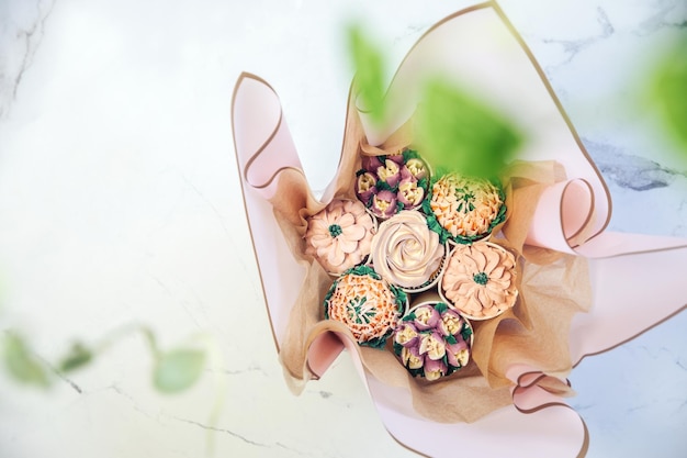 Cupcake decorado con glaseado de flores de varios colores blanco aislado en la parte superior de la sesión de fondo blanco