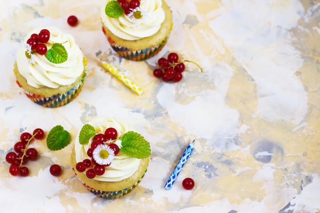 Cupcake festivo con crema y bayas y una vela