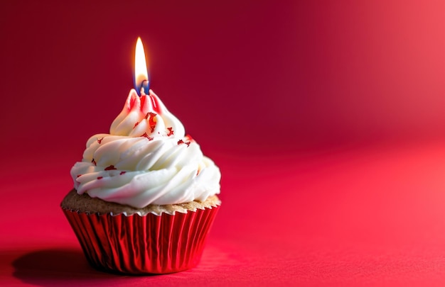 Cupcake mit einer Kerze auf rotem Hintergrund