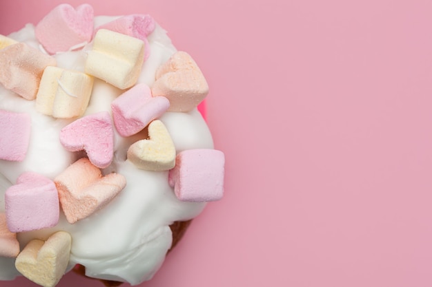 Cupcake mit Herzen von Marshmallow auf einer rosa Hintergrundnahaufnahme