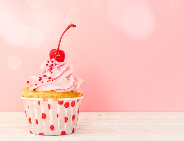 Cupcake mit rosa Sahne und Kirsche