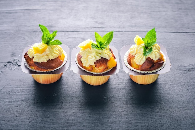 Foto cupcake mit sahne und frischem obst auf einem hölzernen hintergrund ansicht von oben freier platz für ihren text