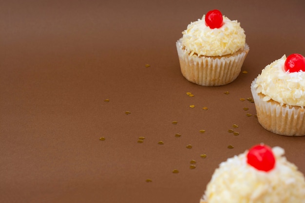 Cupcake mit Vanillebuttercreme, brauner Hintergrund, Geburtstagskonzept. Süßer Nachtisch.