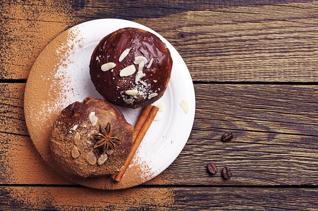 Cupcake mit zwei Schokoladen mit Nüssen auf Vintage-Holztisch. Ansicht von oben