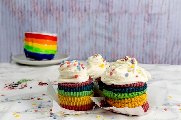 Cupcake o tarta con nata y confeti en los colores del arcoíris Celebración del orgullo LGTBI