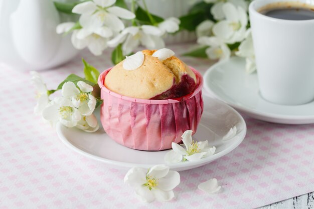 Cupcake oder Muffin mit frischer Blume im Cupcake-Halter aus Papier