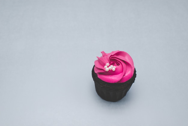 Cupcake rosa sobre um fundo cinza