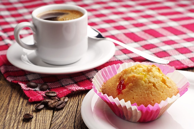 Cupcake y taza de café sobre la mesa