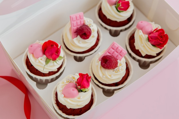 Cupcake und rote Rosen auf einem rosa Raum