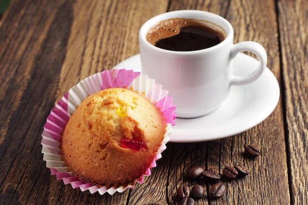 Cupcake und Tasse Kaffee auf einem Holztisch