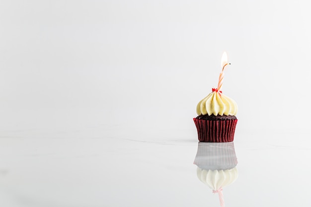 Cupcake con vela fiesta de cumpleaños sobre fondo blanco, concepto de aniversario