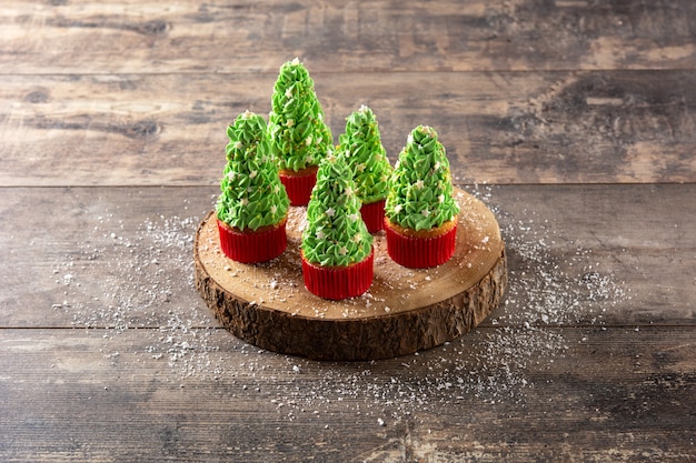 Cupcakes de árbol de Navidad en mesa de madera