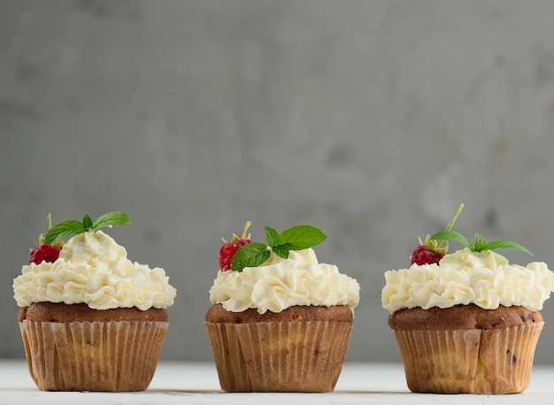 Cupcakes assados com creme de manteiga branca na mesa deliciosa sobremesa