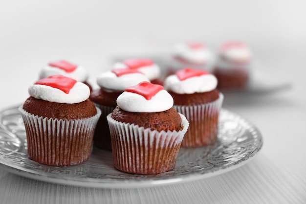 Cupcakes auf Teller auf hellem Holzhintergrund