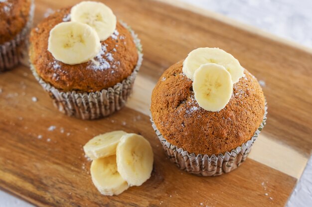 Foto cupcakes caseiros com ingrediente de banana na placa de madeira, receita fácil de muffins, plano de fundo de padaria