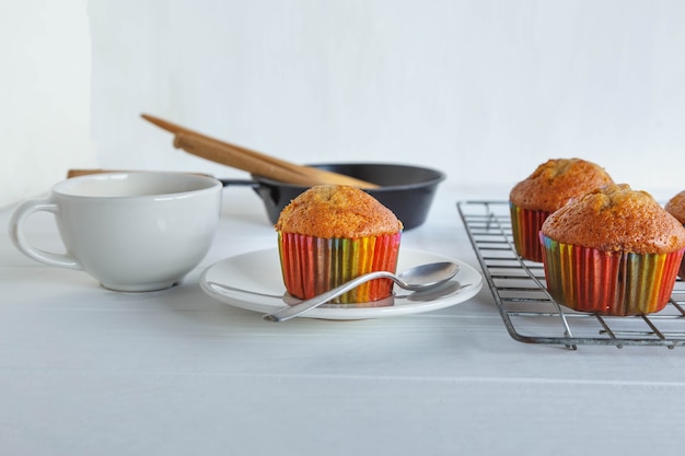 Cupcakes caseiros e xícara de café na mesa branca