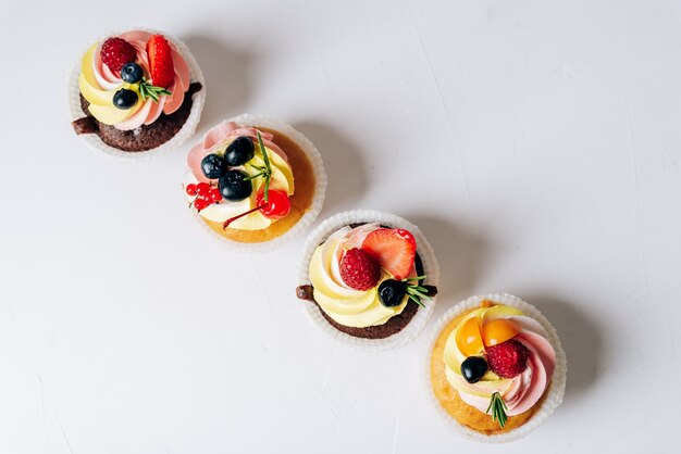 Cupcakes de chocolate con crema y frutos rojos frescos