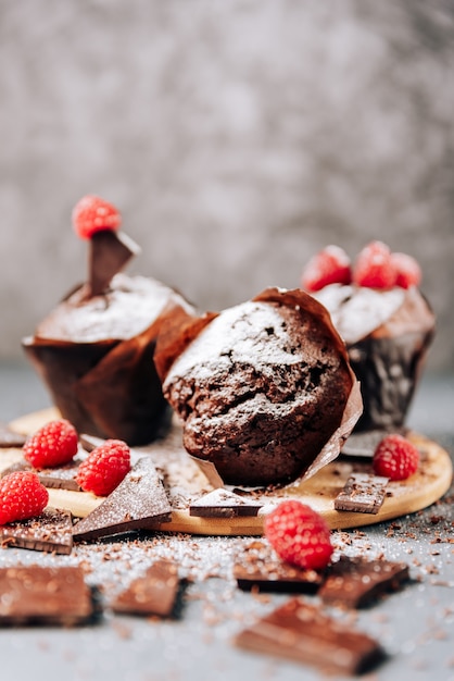 Cupcakes de chocolate con frambuesas y primer plano de chocolate amargo