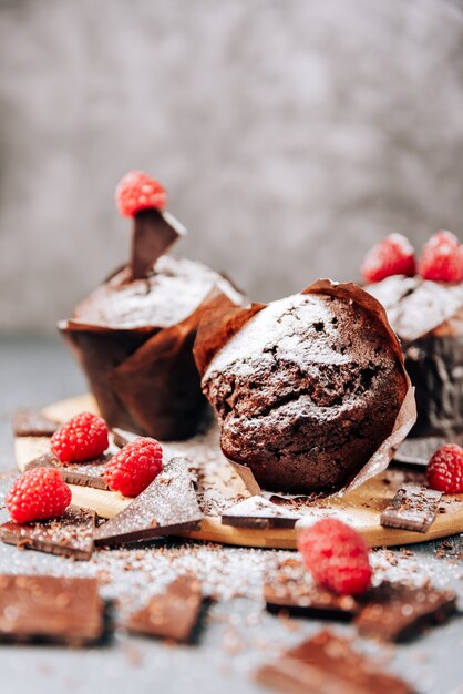 Cupcakes de chocolate con frambuesas y primer plano de chocolate amargo