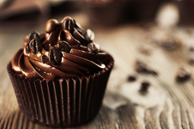 Cupcakes de chocolate y granos de café en la mesa de madera